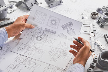 Wall Mural - Engineer technician designing drawings mechanical parts engineering Engine.manufacturing factory Industry Industrial work project blueprints measuring bearings caliper tools