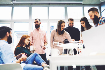 Group of young experts working on development of smart technologies and programs in modern loft.University students on campus planning coursework project.Office workers discuss job during coffee break