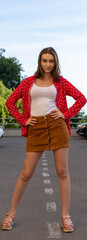 A picture of a girl in a red shirt. she poses in motion in front of the camera. look purposeful, beautiful eyes and open face. High quality photo