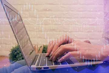 Double exposure of woman hands typing on computer and forex chart hologram drawing. Stock market analysis concept.