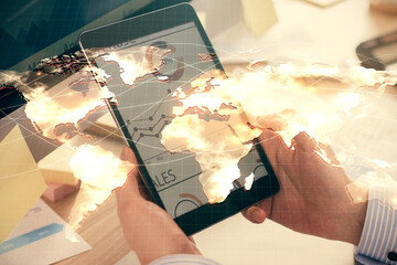 Double exposure of man's hands holding and using a phone and international business theme drawing.