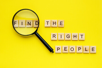 wooden block lettering find the right people and magnifying glass on yellow background. human resour