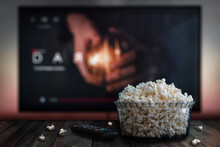 Video Streaming App On Tv Screen Behind A Bowl Of Popcorn And A Remote Control.