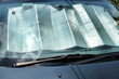 A sunshade shields a car's interior against the heat as the intensity of the midday sun is reflected on the windscreen.