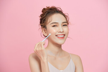 close-up of a young cute girl holding brush in her hand and applying makeup.