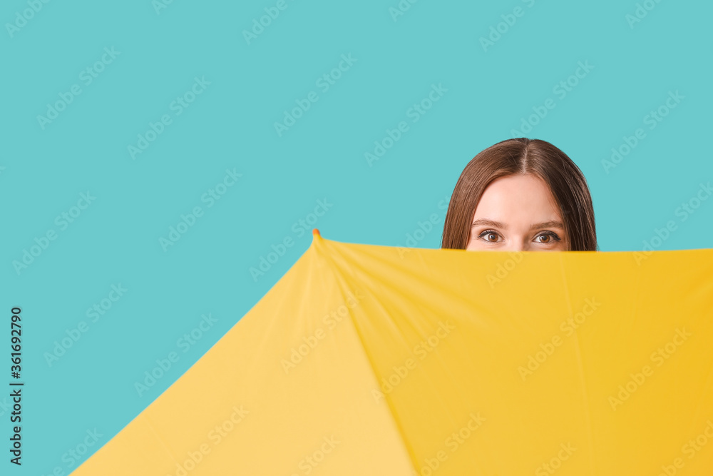 Beautiful woman with umbrella on color background