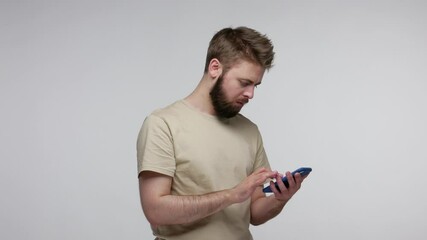 Wall Mural - mobile user, concentrated attentive bearded guy typing message using cellphone to communicate online