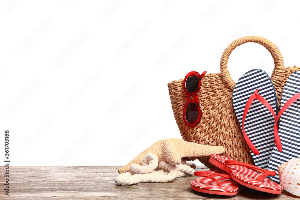 Set of beach accessories on table against white background
