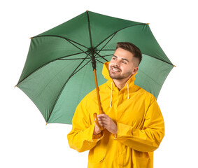 Wall Mural - Young man in raincoat and with umbrella on white background