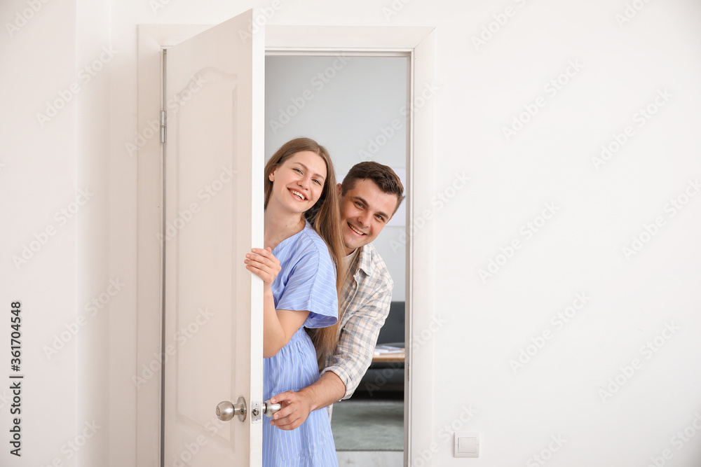 Happy couple looking out the door