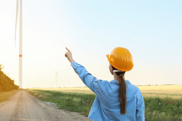 Wall Mural - Female engineer on windmill farm for electric power production