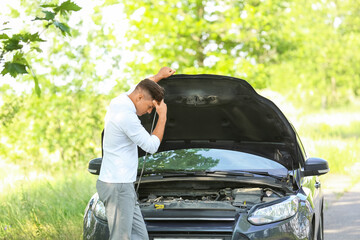 Wall Mural - Young man near broken car on road