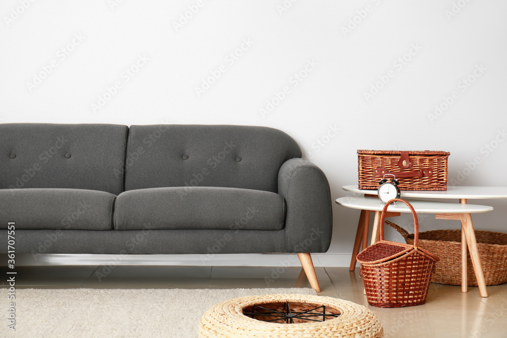 Sofa, table and wicker baskets in room