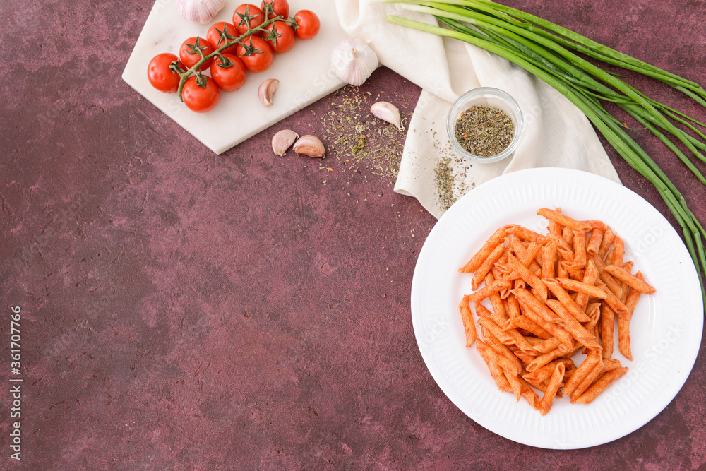 Plate with tasty pasta and tomato sauce on color background