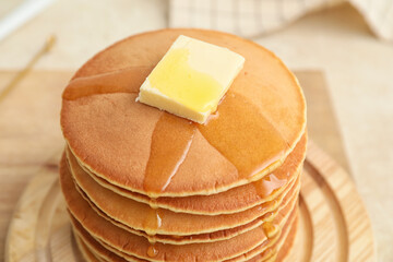 Tasty pancakes with butter and honey on table, closeup