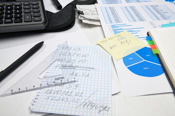 business office desk closeup - financial reports, analysis and accounting, set of documents, tables and graphs, various items for bookkeeping, calculator