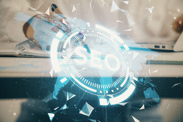 Double exposure of woman's hands making notes with SEO icon. Concept of Search engine optimization