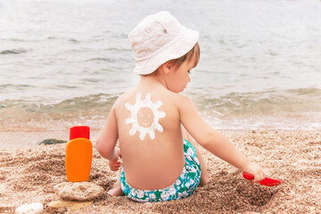 Wall Mural - The sun drawing sunscreen on baby (boy)  back.