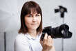 © Di Studio - portrait of young female photographer posing with camera in her studio