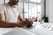 © Drobot Dean - Cropped photo of man working with laptop while sitting at table
