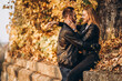 © bedya - Sunny portrait of a young loving couple walking in the autumn park.