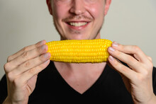 Face Of Happy Young Man Smiling While Holding Corn Cob