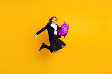 Wall Mural - Full length body size view of nice small little cheerful excited girl jumping having fun vacation pass exam examination test isolated bright vivid shine vibrant yellow color background