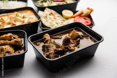 Online food delivery business concept for Indian Restaurant showing plastic containers with veg and non-veg food