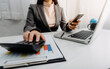 © ARMMY PICCA - Businesswomen hands working with finances about cost and calculator and laptop with tablet, smartphone at office in morning light