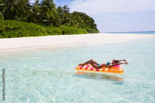 Nice fit slim thin sporty slender attractive girl freelancer businesswoman settling down on island floating lying on rubber mattress ocean water downshift remote work enjoying free lifestyle