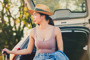 Wall Mural - Beautiful sexy women are happy with nature.Female tourists wearing hats sitting on hatchback car,