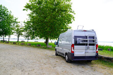 Motorhome RV Campervan Parked On A River Side Beach For Night