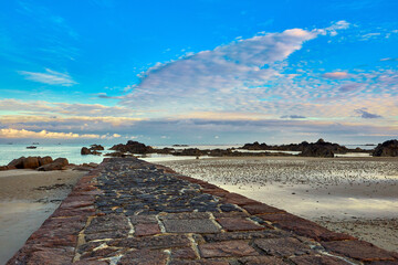 Wall Mural - Image of the stone pier at Green Island with calm sea, beach, blue sky with couds. Jersey, Channel Islands