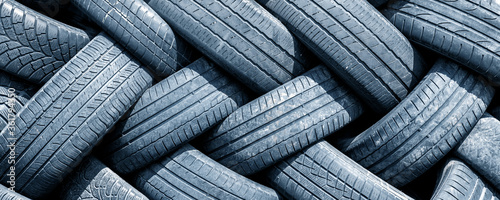 Fotomural Old used weared car and truck wheels tyres pile stacked in rows stored for recycling
