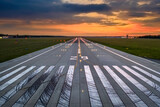 Fototapeta  - Aerial view on empty airport runaway with markings for landings, 29 and all navigation lights on at the colorful sunset, clear for airplane landing or taking off in Wroclaw  airport