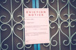© WESTOCK - Foreclosed or eviciton notice on a main door with blurred details of a house with vintage filter.