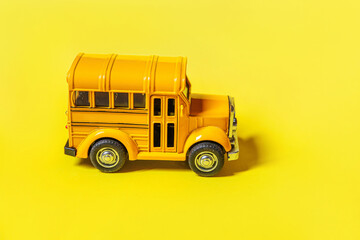 Simply design yellow classic toy car school bus isolated on yellow colorful background. Safety daily transport for kids. Back to school concept. Education symbol, copy space