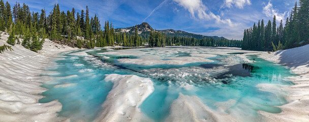 Wall Mural - a warm summer day helps speed the melting of snow and surface ice on a high mountain lake.