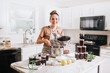 Woman canning homemade blackberry jam in home kitchen