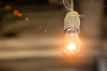Old Incandescent Lamp In Dust And Cobweb On Brown Background