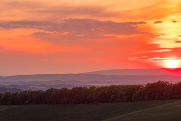 Sticker - The setting sun over the forested mountain landscape of the Beskydy region, the sun sets beyond the horizon.