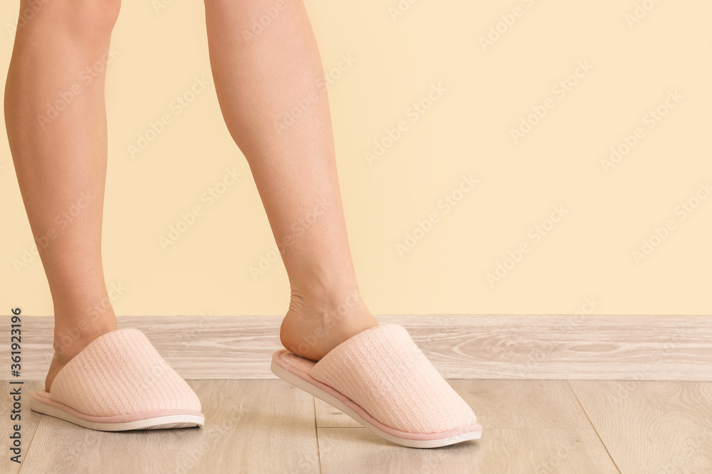 Woman in soft slippers near color wall