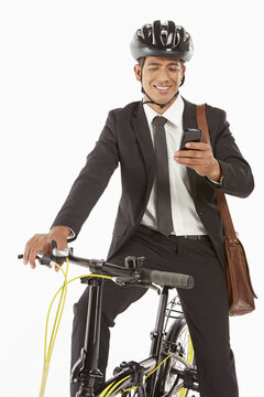 Businessman on bicycle reading text message