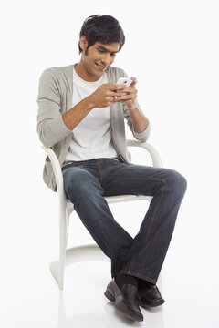 Man sitting on a chair, text messaging