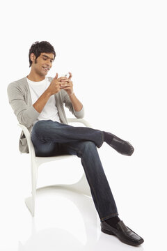 Man sitting on a chair, text messaging