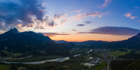 Wall Mural - panorama of village pflach in austrian mountains with river lech at colorful sunset