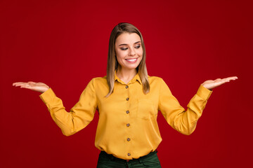 Portrait of her she nice-looking attractive lovely cute cheerful cheery girl holding on two palms ad advert advice deciding choosing isolated over bright vivid shine vibrant red color background