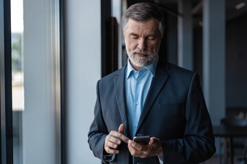 Businessman using mobile phone app texting. Mature caucasian man holding smartphone for business work