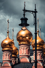 Black City Light Against The Background Of Three Golden Domes Of The Church