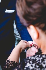 Canvas Print - Vertical shot of a female tying the watch on the wrist of the male